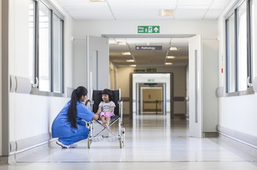 Fototapeta na wymiar Female Girl Child Patient in Wheelchair & Hospital Nurse