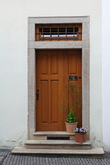 wooden door with stairs and flower in pots