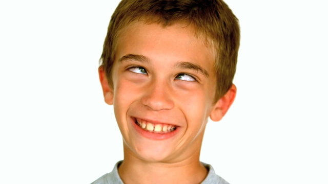 Little boy squinting against white background