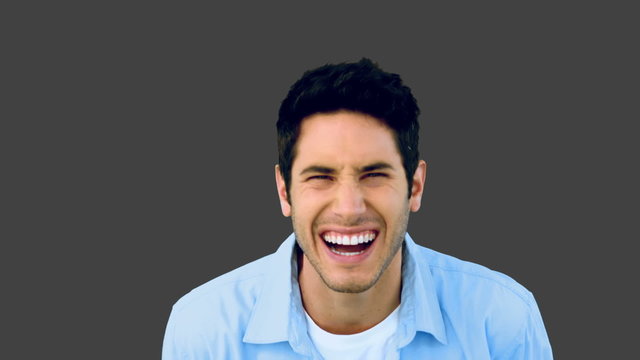Man laughing at the camera on grey background