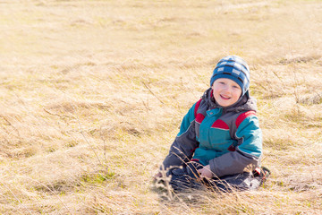 Child on dry grass (field)