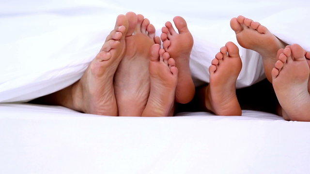Familys feet peeking from under the covers