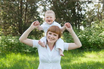 Fototapeta premium smiling mother holding a child on his shoulders