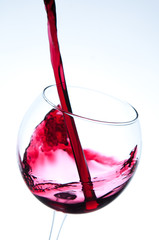 Red wine pouring into wine glass