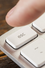 Finger Pressing Escape on a Grey Computer Keyboard