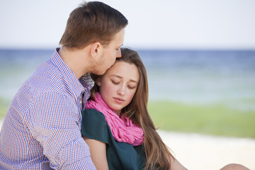 Fototapeta na wymiar Portrait of young man and woman kissing on a beach
