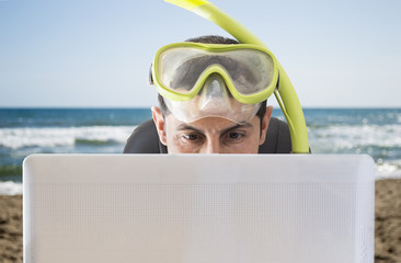 Man smiling at web prices for his holidays & trips on the beach