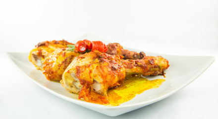 Tandoori chicken in a plate over white background