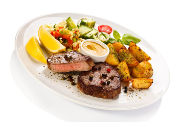 Grilled steak, baked potatoes and vegetables