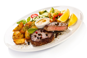 Grilled steak, baked potatoes and vegetables