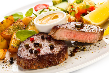Grilled steak, baked potatoes and vegetables