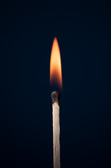 Match burning on a dark background