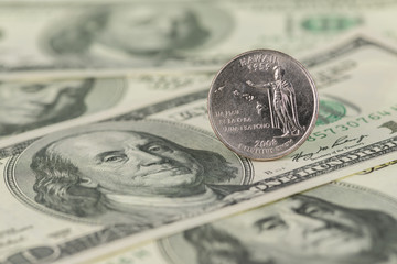 Hawaii State Quarter coin on one hundred dollar bills close up