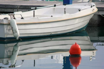 Fototapeten kleines weißes Motorboot aus Kunststoff mit Spiegelung in ruhigem Wasser © William Richardson