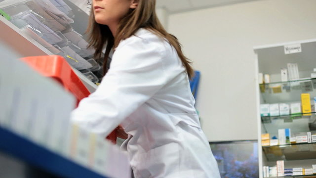 Female pharmacist controlling medicine drugs pills
