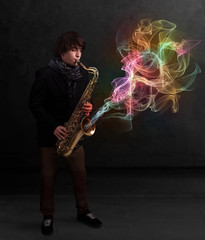 Attractive musician playing on saxophone with colorful abstract