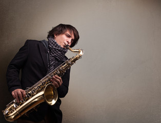 Naklejka premium Young musician playing on saxophone