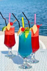 Colorful exotic drinks served on the rocks at the seaside.