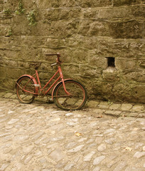 Fototapeta na wymiar old child bicycle with cobble and wall