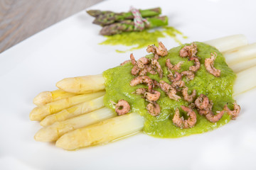 Delicious bunch of white asparagus with green sauce