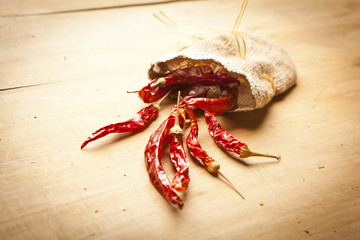 Red hot dry chili peppers over wooden background