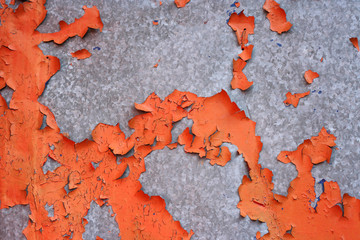 flaking old orange paint on a stainless steel surface