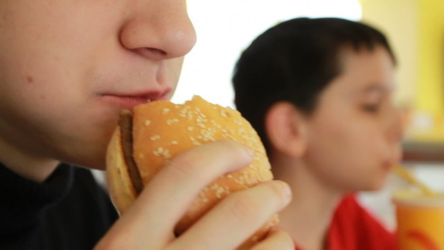 caucasian boy eating burger
