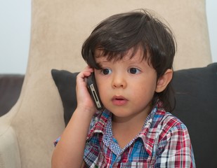 handsome smart kid talking by mobile phone