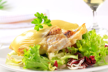 Cheese topped fish fillets with salad