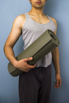 Young mixed race man carrying yoga mat