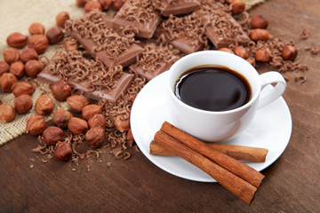 Сup of coffee with cinnamon sticks in a saucer.