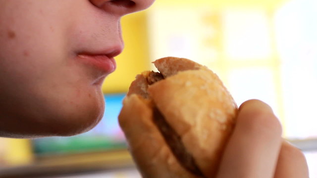 caucasian boy eating burger