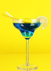 Blue cocktail in glass on color background