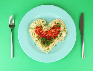Cooked spaghetti carefully arranged in  heart shape and topped
