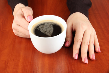 Hands holding mug of hot drink, close-up