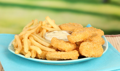 Fried chicken nuggets with french fries and sauce