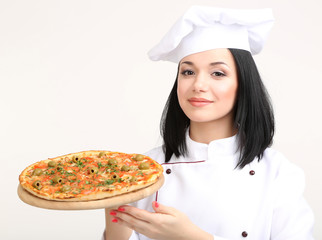 Beautiful girl chief-cooker with pizza isolated on white