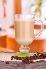 Layered coffee in glass on table on bright background