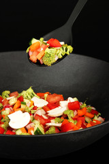 Vegetable ragout in wok, isolated on black