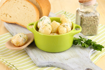 Tender young potatoes with sour cream and herbs in pan