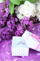Beautiful box with wedding ring on purple background