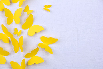 Paper yellow butterflies fly on wall in different directions