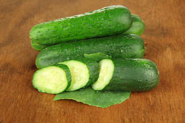 Tasty green cucumbers on wooden background