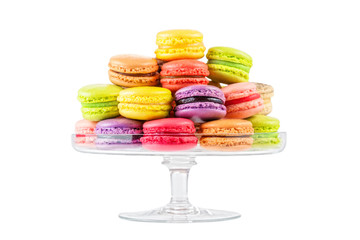 macarons colorés français dans un support à gâteaux en verre