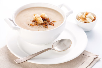 Cauliflower soup with croutons on white background
