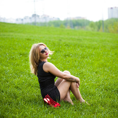 Fototapeta premium beautiful young blond woman sitting on the grass.