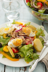 nicoise salad over blue wood background