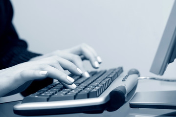 Female hands typing on computer keyboard