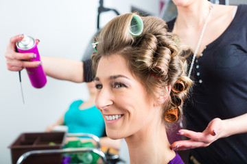 Fototapeta premium Hairdresser - hair stylist curling hairs
