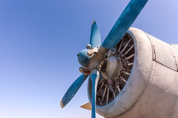 Propeller and engine of old airplane against blue sky